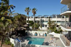 an aerial view of a hotel with a pool and palm trees at Chateau Royale Beach Resort in Maroochydore