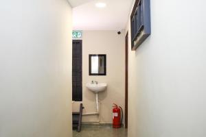 een hal die leidt naar een badkamer met een wastafel en een brandblusser bij OYO 90338 Prima Saujana Budget Hotel in Kajang