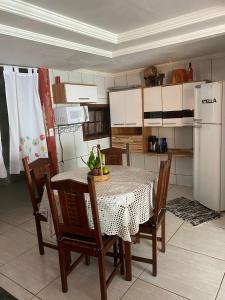 una cucina con tavolo, sedie e frigorifero di Casa da Suh a Parati