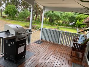 a grill on a screened in porch with a deck at Lazy Days Cottage - Victor Harbor in Hindmarsh Valley