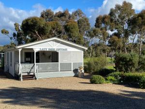 a white shed with a sign that reads new mini quarters at Lazy Days Cottage - Victor Harbor in Hindmarsh Valley