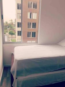 Ένα ή περισσότερα κρεβάτια σε δωμάτιο στο Moderno APTO con aire acondicionado y Netflix en Villavicencio