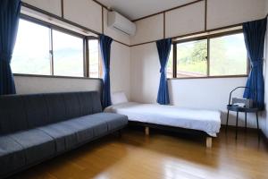 a living room with a couch and two windows at Classic Japan Living ASAMA in Fujikawaguchiko
