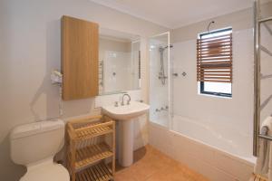 a bathroom with a toilet and a sink and a shower at Dunsborough Beach Cottages in Dunsborough