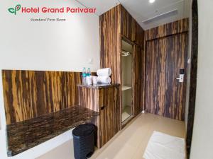 a bathroom with wood paneling and a shelf in a room at Hotel Grand Parivaar in Igatpuri +43 photos