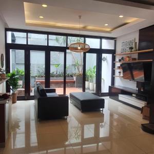 - un salon avec un canapé et une télévision dans l'établissement Cottonwood 4BR Villa Sutami with Pool Netflix BBQ, à Bandung