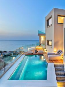 a house with a swimming pool and the ocean at Alectrona Living Crete, RocSea Luxury Apartment in Plataniás