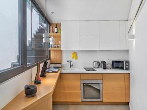 eine Küche mit weißen Schränken, einem Waschbecken und einem Fenster in der Unterkunft Alectrona Living Crete, RocSea Luxury Apartment in Platanias