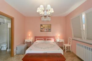 a bedroom with pink walls and a bed and a chandelier at La Papaya in Marina di Pisa