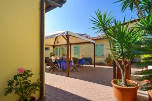 a patio with a table and an umbrella at La Papaya in Marina di Pisa