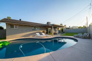 a swimming pool in front of a house at Splash and Relax by HomeSlice Stays in Scottsdale