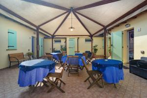 a covered patio with blue tables and chairs at La Papaya in Marina di Pisa