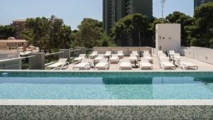 a swimming pool with lounge chairs and a swimming pool at Iberflat APARTAMENTOS LOS PINOS in Benicàssim