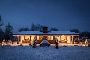 une maison recouverte de neige la nuit dans l'établissement Thomhof Chalets, à Bran