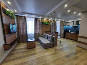 a living room with a couch and a television at Исы Байзакова 133 in Pavlodar