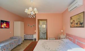 a bedroom with two beds and a chandelier at La Papaya in Marina di Pisa