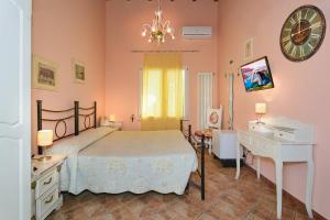 a bedroom with a bed and a desk and a clock at La Papaya in Marina di Pisa