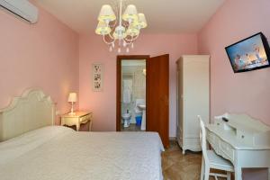 a bedroom with a bed and a desk and a tv at La Papaya in Marina di Pisa +37 photos