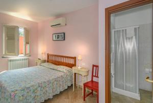 a bedroom with a bed and a table and a chair at La Papaya in Marina di Pisa