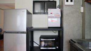 a shelf in a kitchen with two refrigerators at 棲息所 Habitat Inn in Yuanlin