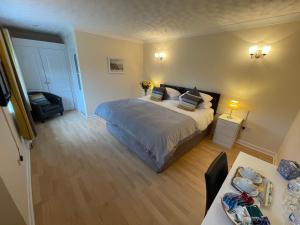 Un dormitorio con una cama y una mesa. en Aldercarr Hall en Attleborough