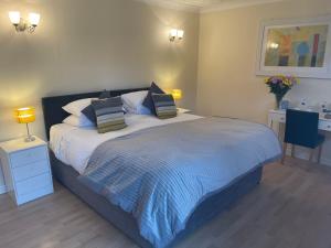 a bedroom with a large bed with two pillows at Aldercarr Hall in Attleborough