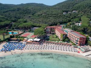 einen Luftblick auf ein Resort und einen Strand mit Sonnenschirmen in der Unterkunft Hotel Desiree in Procchio