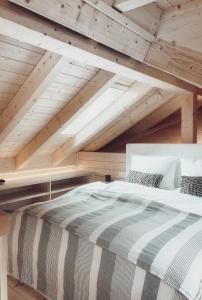 Cama grande en habitación con techo de madera en Lieblingsort - Cosy Black Forest Chalets, en Neuenweg