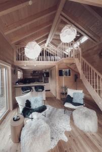 a living room with two chairs and a staircase at Lieblingsort - Cosy Black Forest Chalets in Neuenweg