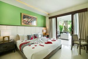 a bedroom with a large bed with red roses on it at Royal Samaja Villas in Seminyak