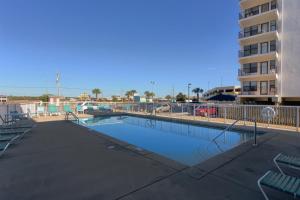 a swimming pool in front of a building at Island Shores Condos in Gulf Shores
