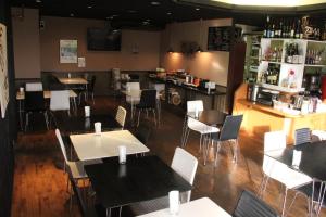 a restaurant with tables and chairs and a bar at Green Rich Hotel Suizenji in Kumamoto
