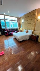 1 dormitorio con 1 cama grande y suelo de madera en Charming Motel, en Hualien City