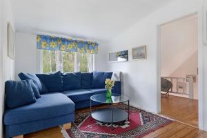 a blue couch in a living room with a table at Charming 3BR country house near Piteå & Skellefteå in Piteå