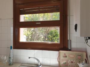 una cocina con una ventana sobre un fregadero de cocina en Xaloc, apartament amb vistes a mar M4, en Port de la Selva