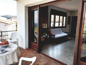 Habitación con mesa y vistas a un balcón. en Xaloc, apartament amb vistes a mar M4, en Port de la Selva