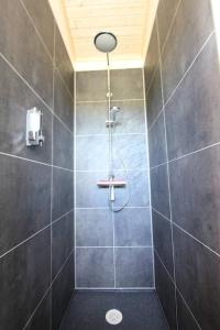 een badkamer met een douche met een douchekop bij Blue View Cabin 6B With private hot tub in Reykholt