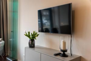 een woonkamer met een tv en een kaars op een dressoir bij Arbio I Duxen Apartments Hagenbeck Zoo in Hamburg