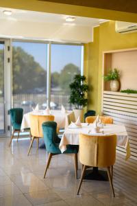 a restaurant with tables and chairs and a large window at Euro Garni Hotel in Belgrade