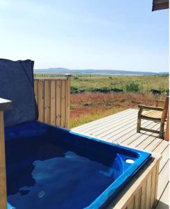 レイクホルトにあるBlue View Cabin 6B With private hot tubのデッキ(ベンチ付)に設置された青いバスタブ