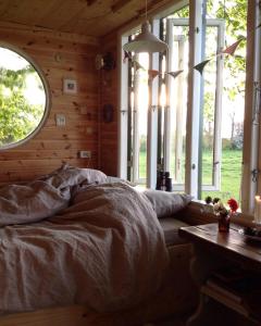 a bedroom with a bed in a room with windows at Treehouse escape in Kværndrup