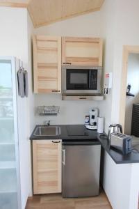 a small kitchen with a sink and a microwave at Blue View Cabin 7B With private hot tub in Selfoss