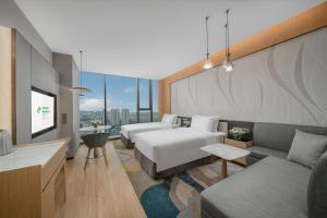 a hotel room with two beds and a couch at Holiday Inn Luzhou Longjian, an IHG Hotel in Luzhou