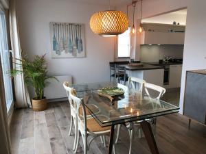 uma cozinha e sala de jantar com uma mesa de vidro e cadeiras em PERLIERES T2 lumineux vue bassin parking wifi em Arcachon