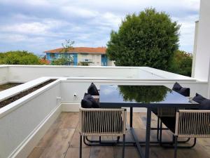 a patio with a table and chairs on a balcony at PERLIERES T2 lumineux vue bassin parking wifi in Arcachon