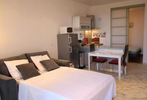 a living room with a white bed and a kitchen at Happyfew Eros in Nice