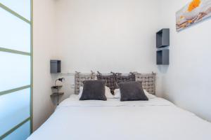 een slaapkamer met een wit bed met 2 kussens bij Happyfew Eros in Nice