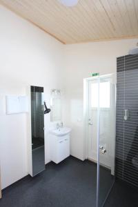 a white bathroom with a sink and a shower at Blue View Cabin 6A With private hot tub in Reykholt