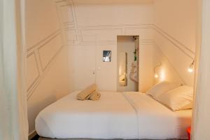 - une chambre avec un lit blanc dans l'établissement Mini Loft au coeur du Panier - Marseille, à Marseille