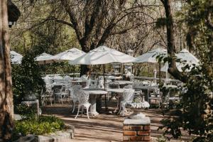 a group of tables and chairs with white umbrellas at Arcadia Luxury Guesthouse in Kroonstad